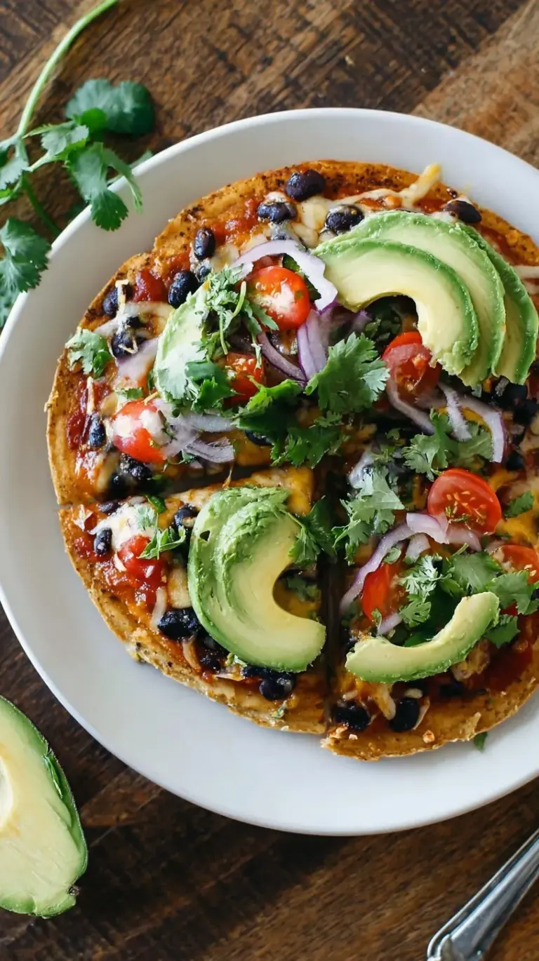 Double layered crispy corn tortilla pizza topped with black beans, melted cheese, and fresh tomatoes.