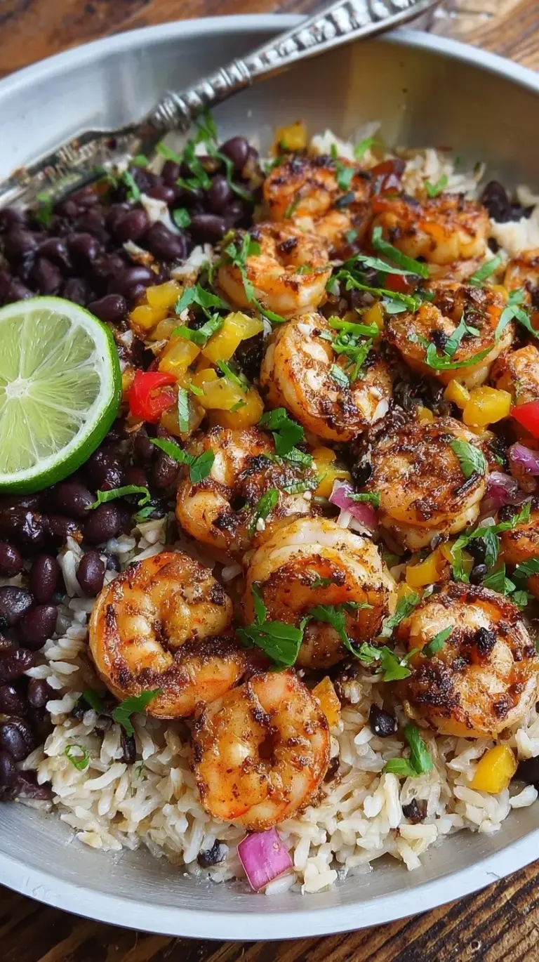 A bowl of grilled jerk shrimp over creamy coconut rice and black beans with green onions.