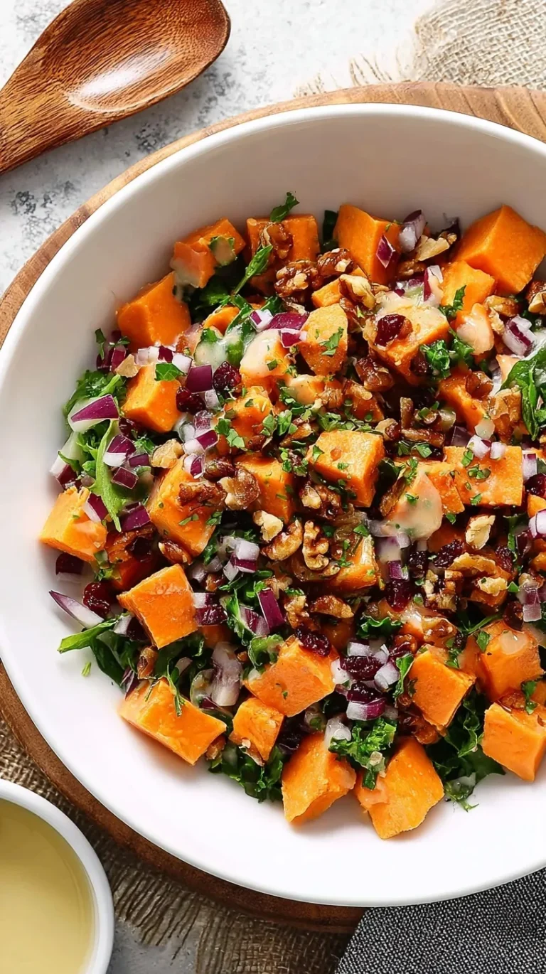 Sweet potato salad with roasted cubes, red onion, celery, and honey mustard dressing in a white serving bowl