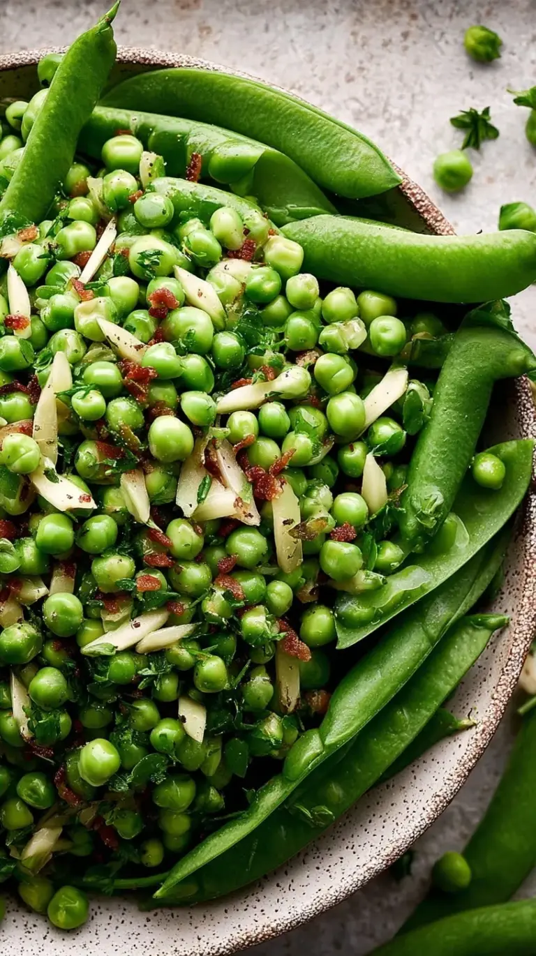 A close-up of a bowl of vibrant green Thanksgiving peas with a hint of butter and fresh herbs, ready to serve.